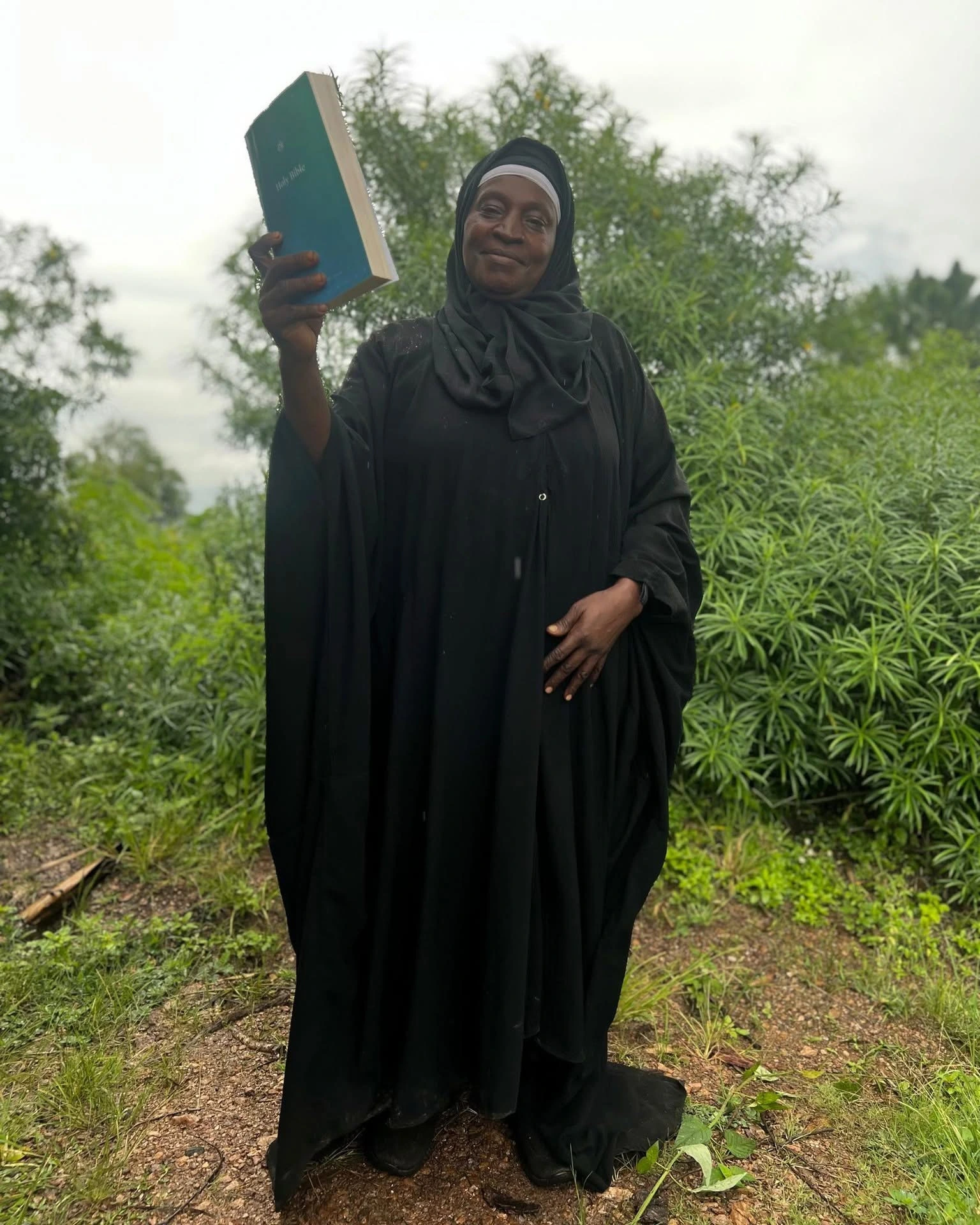 A believer holds a Bible she received in Uganda
