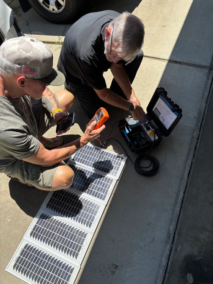 Team checking solar power with the VillageServer case outdoors